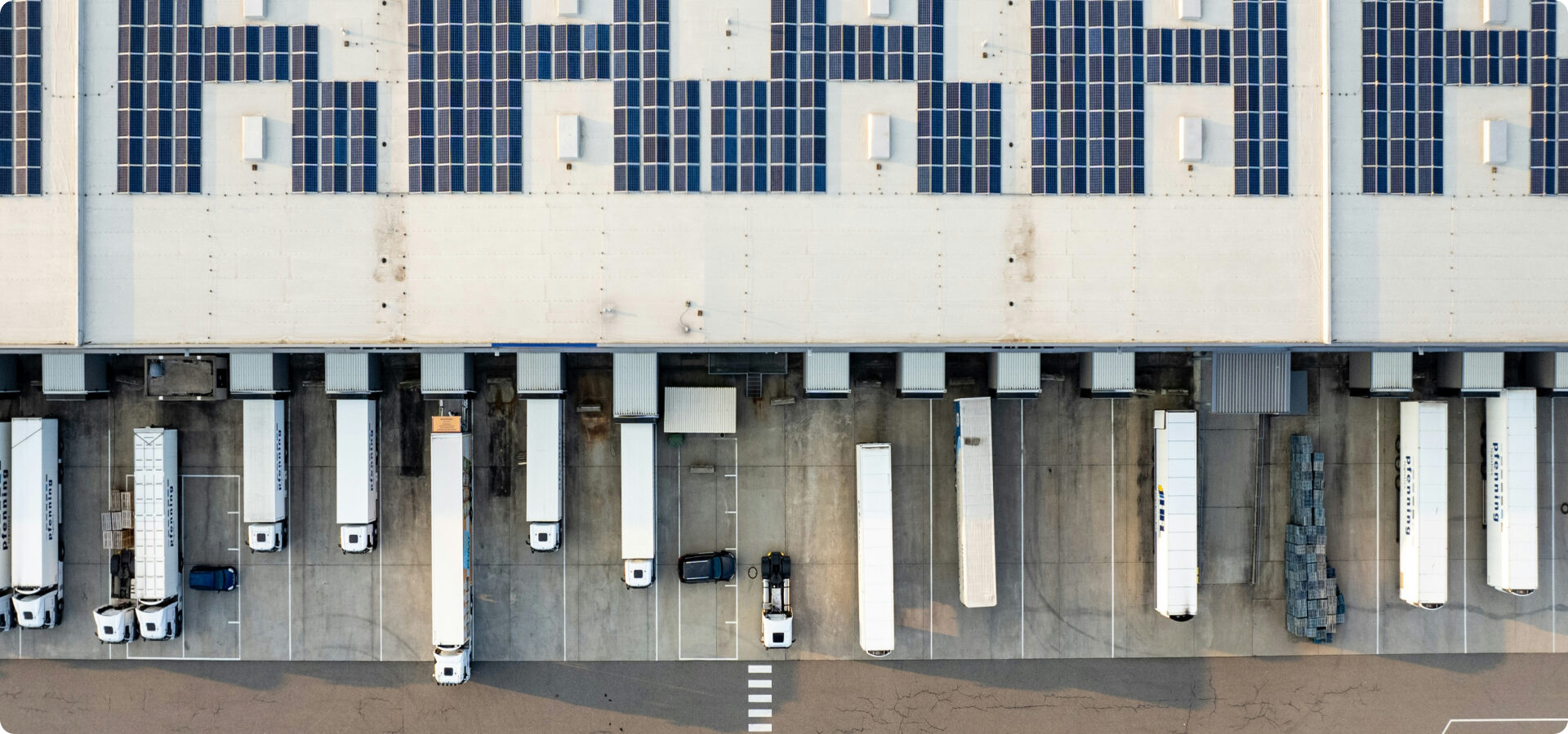 Aerial view of a logistics warehouse covered in solar panels