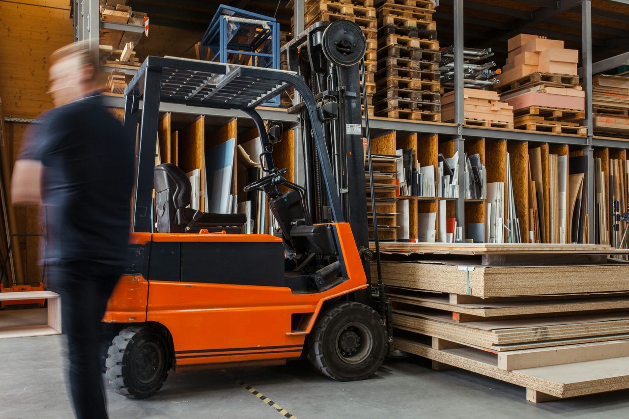 A forklift carries panels through a warehouse